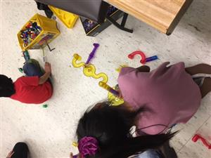 students creating marble runs with plastic tracks and Legos